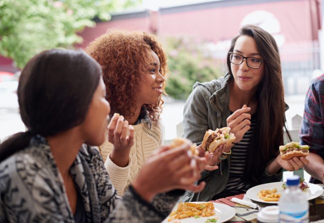 Students eating and socializing together, forming stronger bonds that will allow them to work together better.