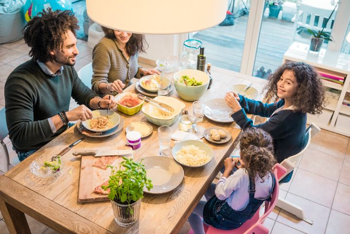 A family eating together providing a strong foundation of socialization for their children.